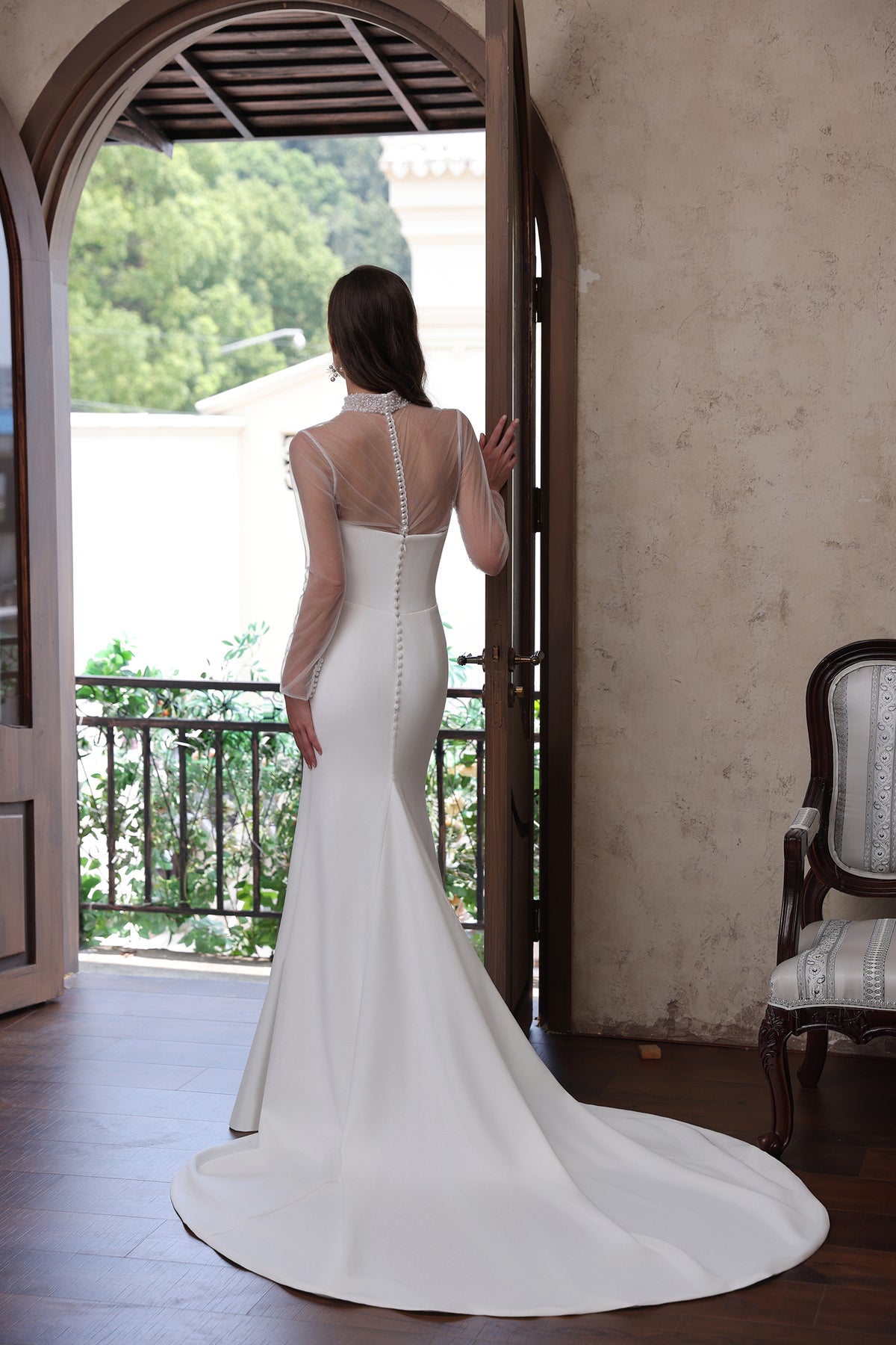 Back of mermaid wedding dress with sheer long sleeves, button detailing and sweeping train