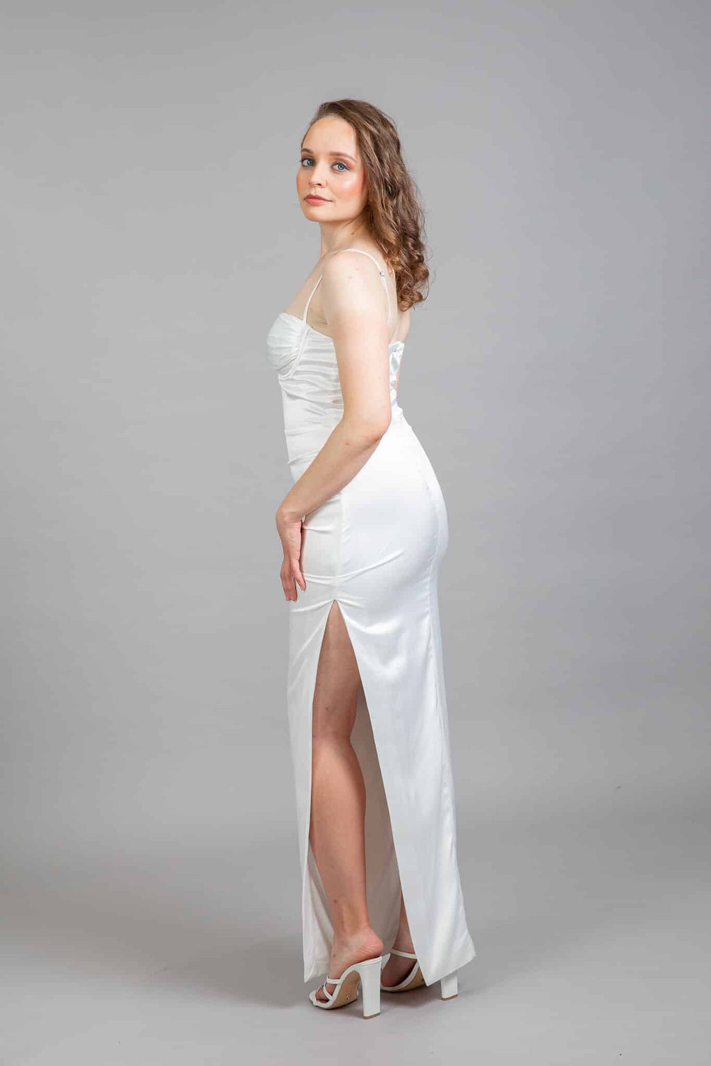 Bride wearing white sweetheart neckline dress with back slit detail and sheer panel, rear view
