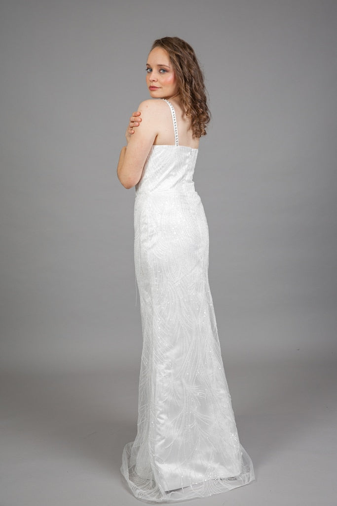 Back view of reception wedding dress showing sweetheart neckline with button-back closure, beaded leaf pattern, flowing train