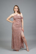 Model in rose gold all-over sequin gown with asymmetric off-shoulder neckline and high leg slit, front view