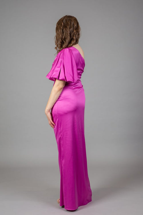 Back view of fuchsia one-shoulder satin gown with billowy puff sleeve and floor-length ruched skirt