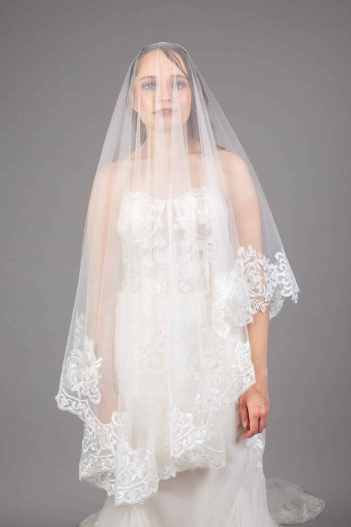 Bride wearing ivory tulle cathedral veil with lace appliqué scalloped edge and blusher, front view – Art Kollocsion Auckland