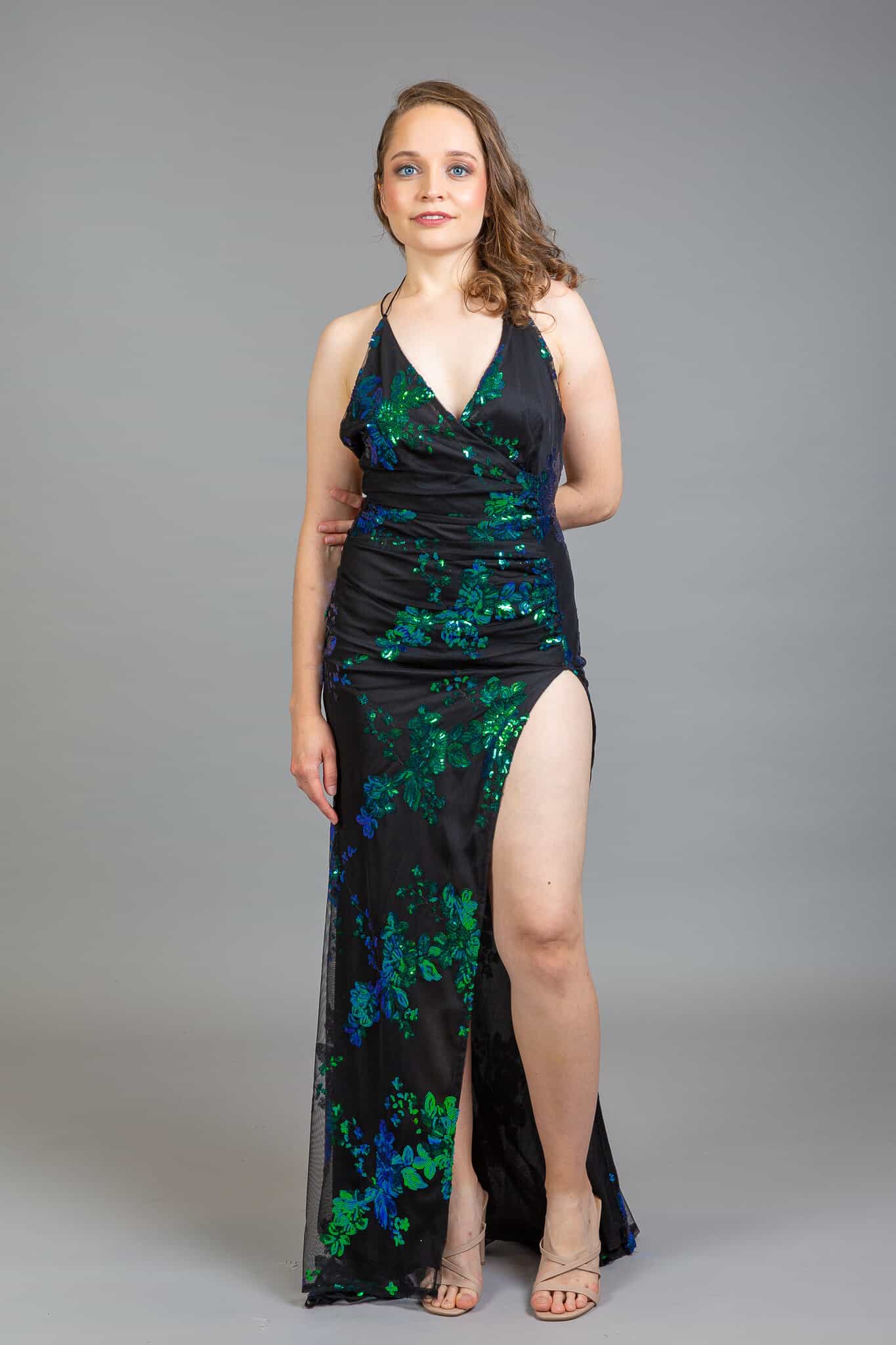 Black sequined dress with emerald and blue floral pattern, halter neckline, ruched bodice, thigh slit