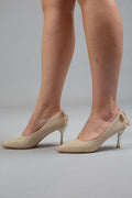 Model wearing matte golden heels with pointed toe, slim heel, and bow detail – Art Kollocsion Auckland