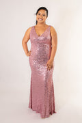 Front view of pink sequin maxi dress with deep V-neckline and fitted bodice on model