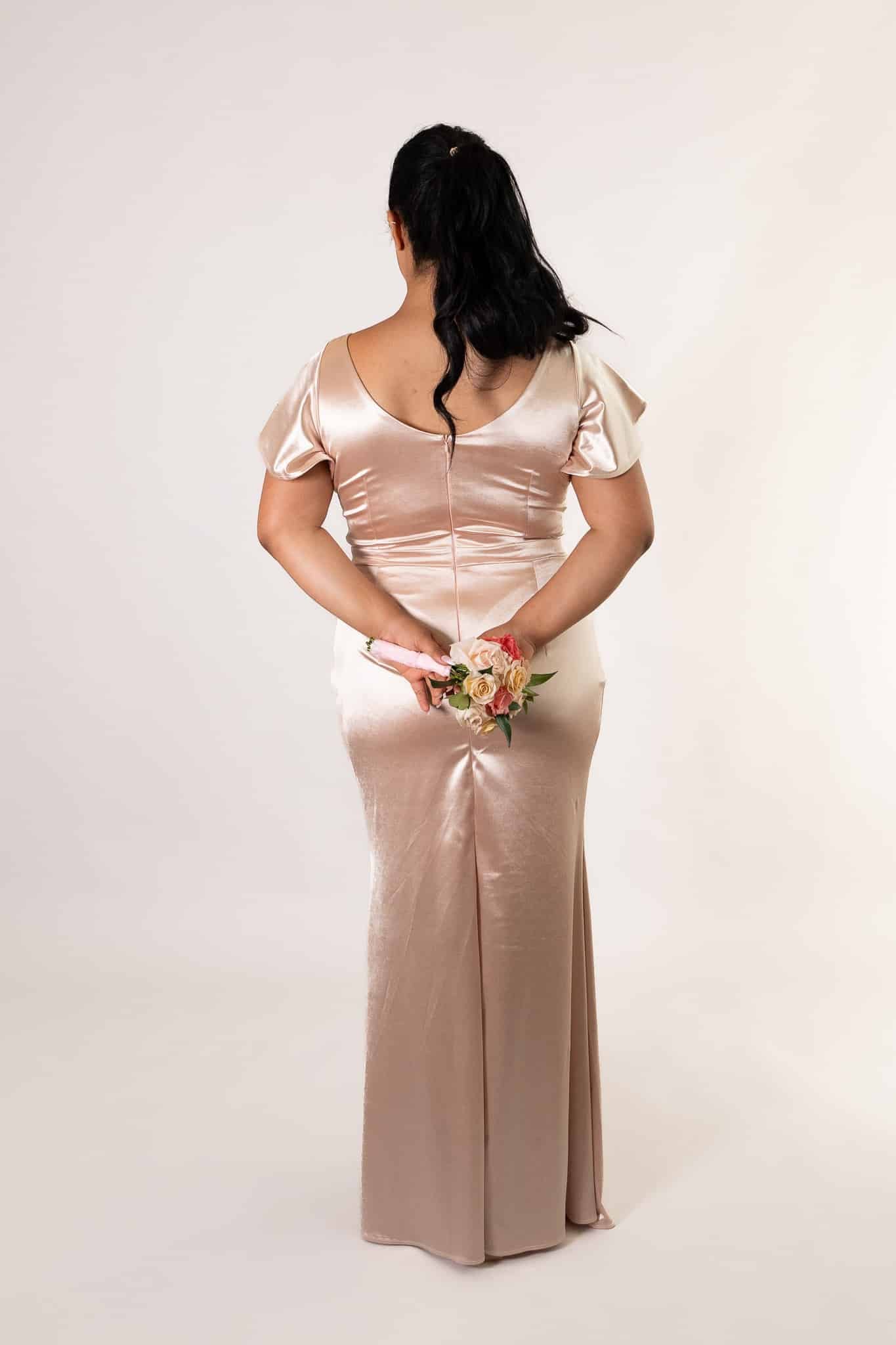 Back view of blush satin bridesmaids dress with center zip and flowing train