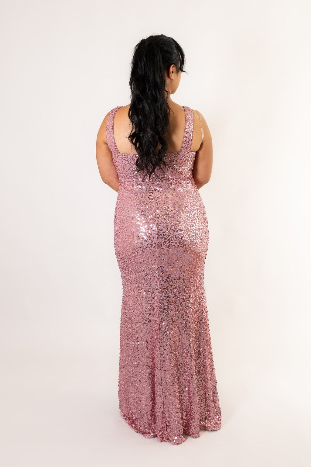 Back view of sequin dress featuring sleeveless design with squared neckline and flowing hemline