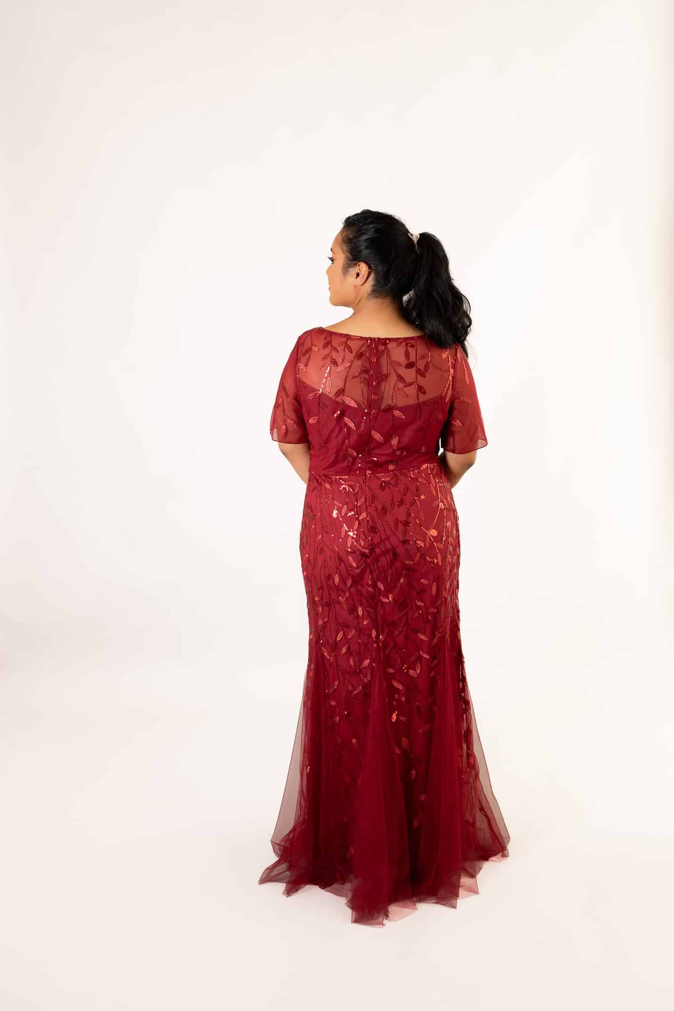 Back view of red tulle dress with short sleeves, showing fitted bodice and flowing train