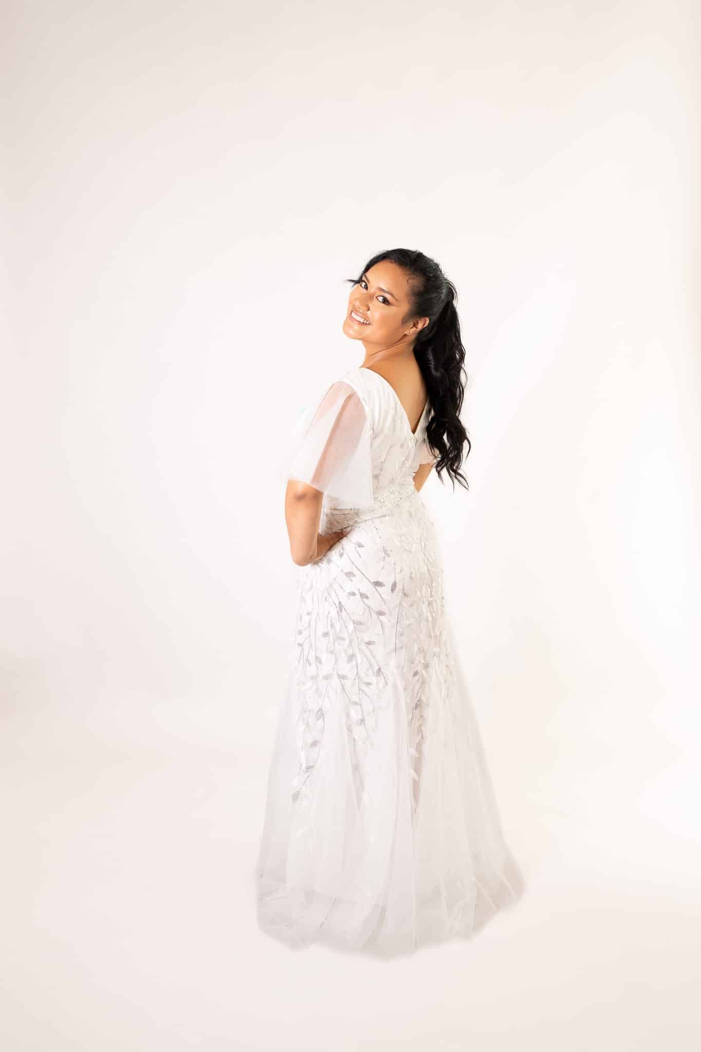 Model wearing white tulle dress with beaded bodice and butterfly sleeves, back three-quarter view – Art Kollocsion Auckland