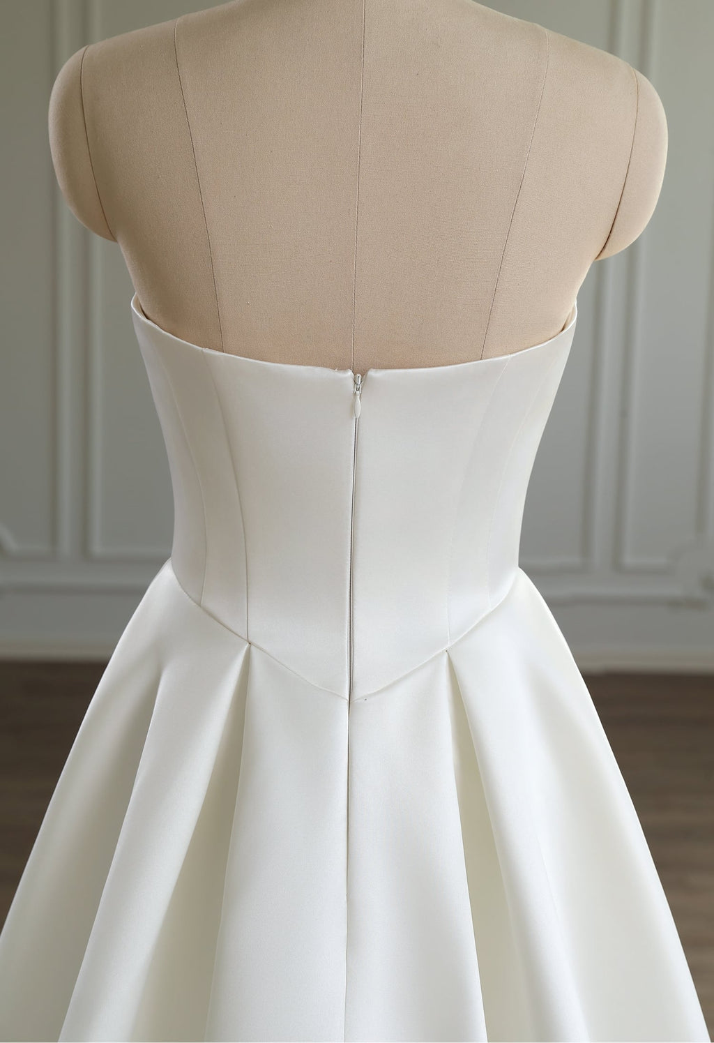 Back view of ivory satin dress showing zip-up closure and structured satin bodice