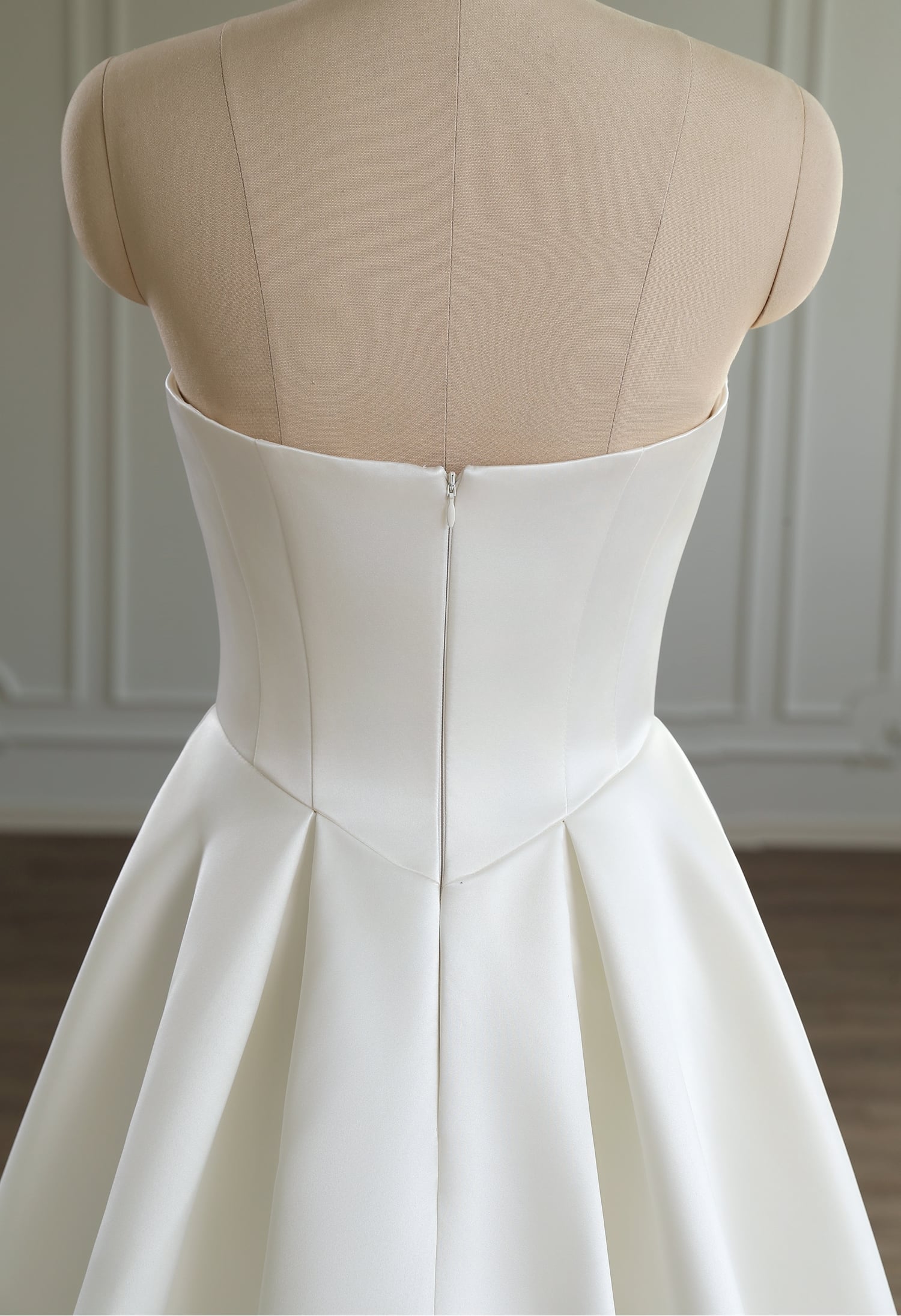 Back view of ivory satin dress showing zip-up closure and structured satin bodice