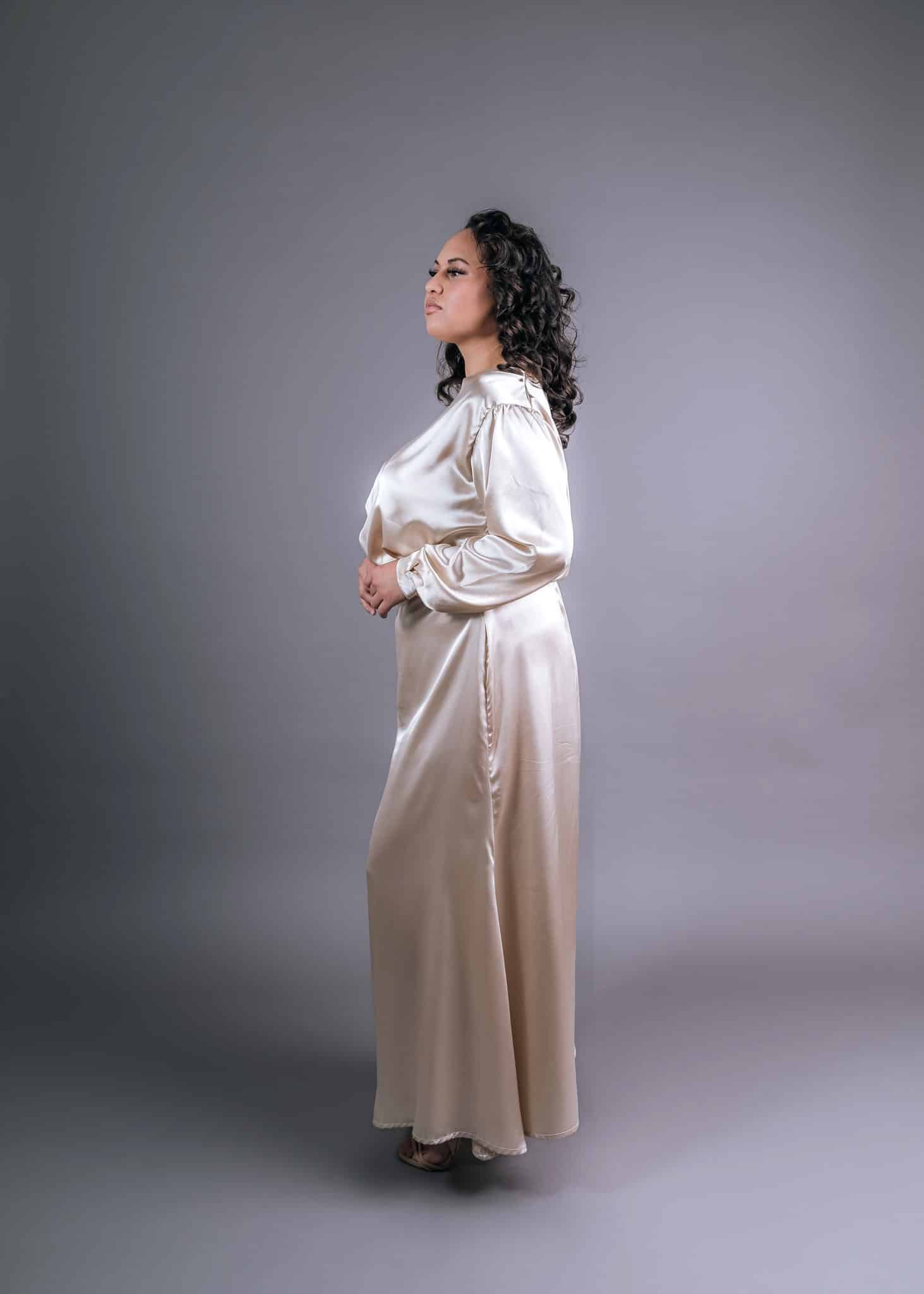 Side profile of ivory silk two-piece combination with gathered puff sleeves and flowing maxi skirt