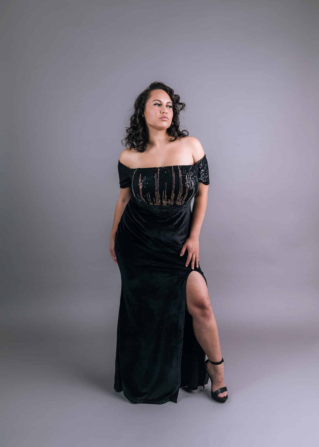 Black sequined velvet formal dress front view with cut-out detail and high leg slit
