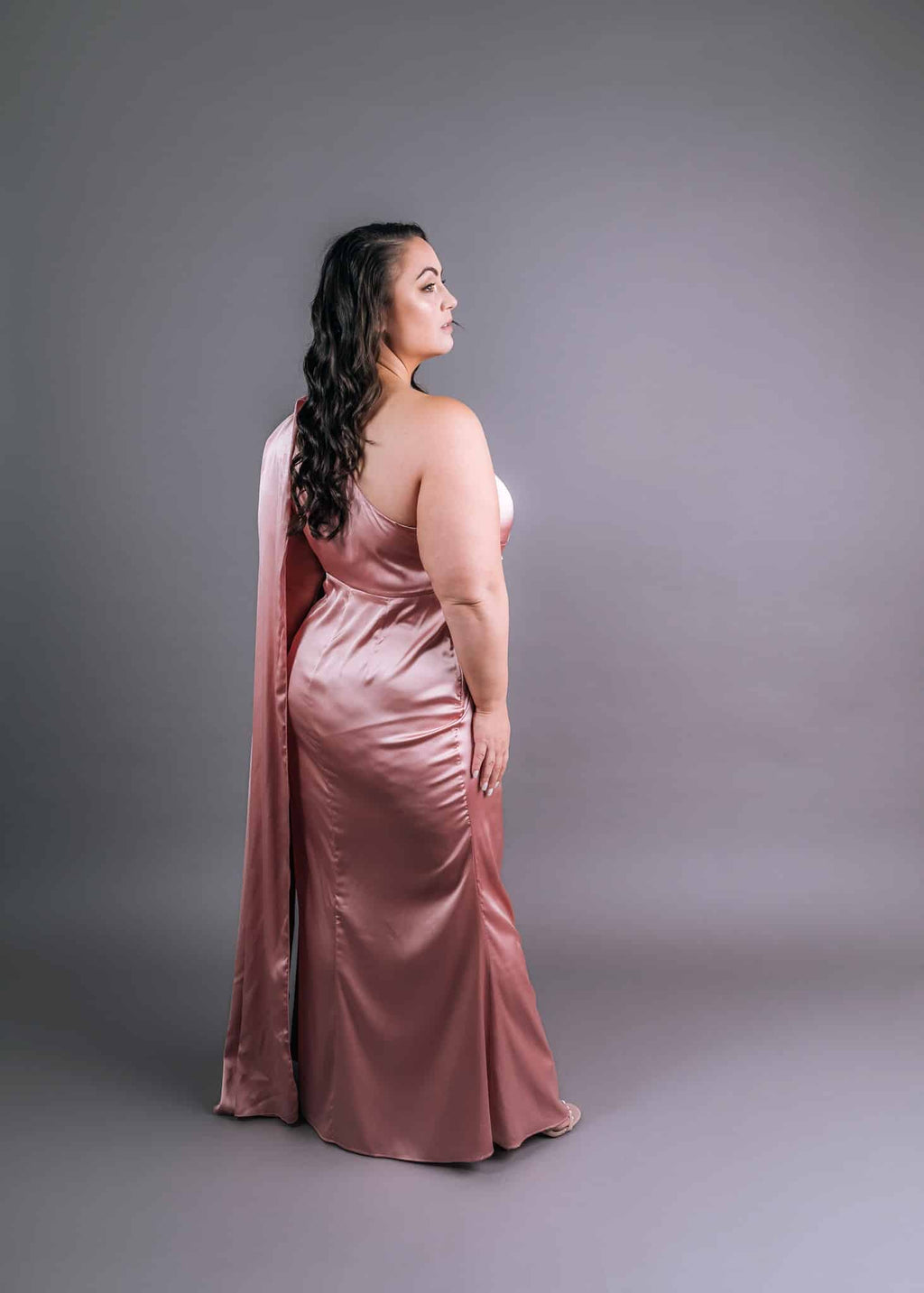 Back view: deep rose satin evening gown with draped shawl, low back detail and floor-length train