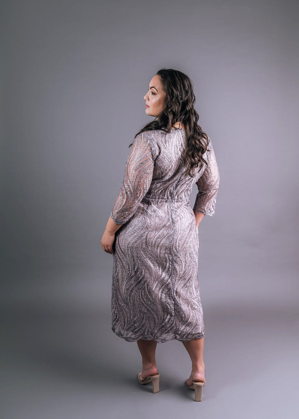 Back view of taupe dress showing wavy pattern and three-quarter sleeves