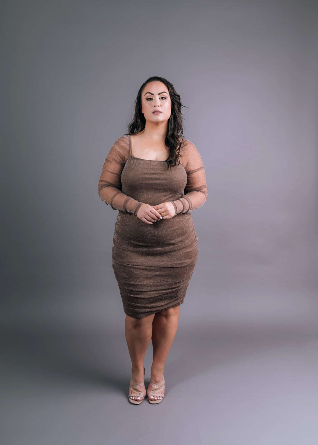 Beige shimmery dress with long mesh sleeves and square neckline, front view showing ruched bodice detail