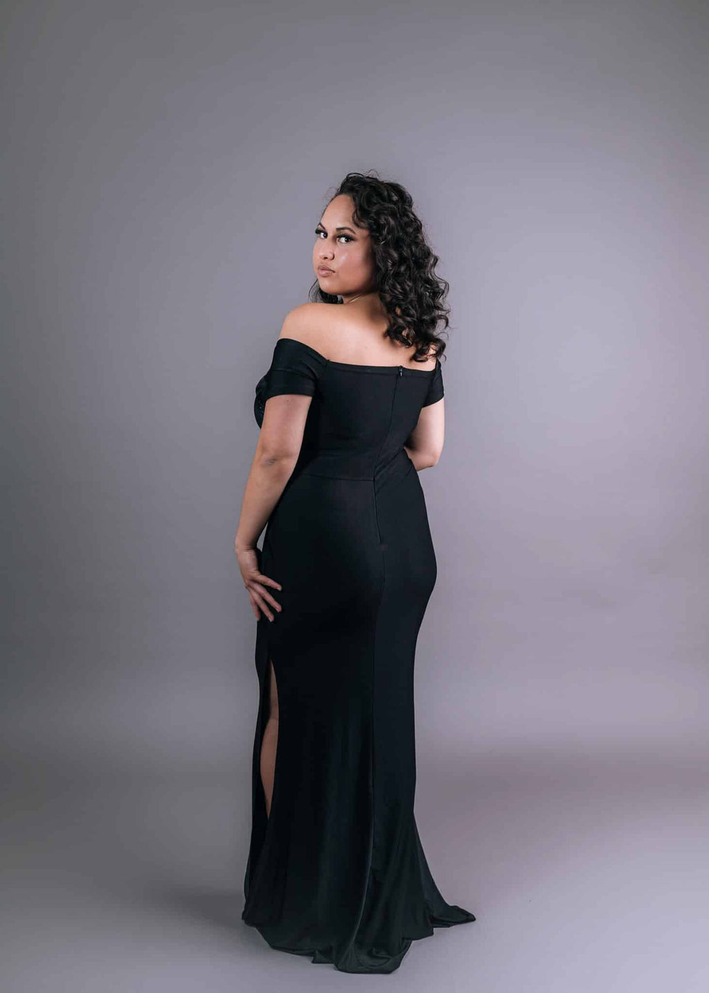 Back view of black slinky dress with elegant rear neckline and flowing train
