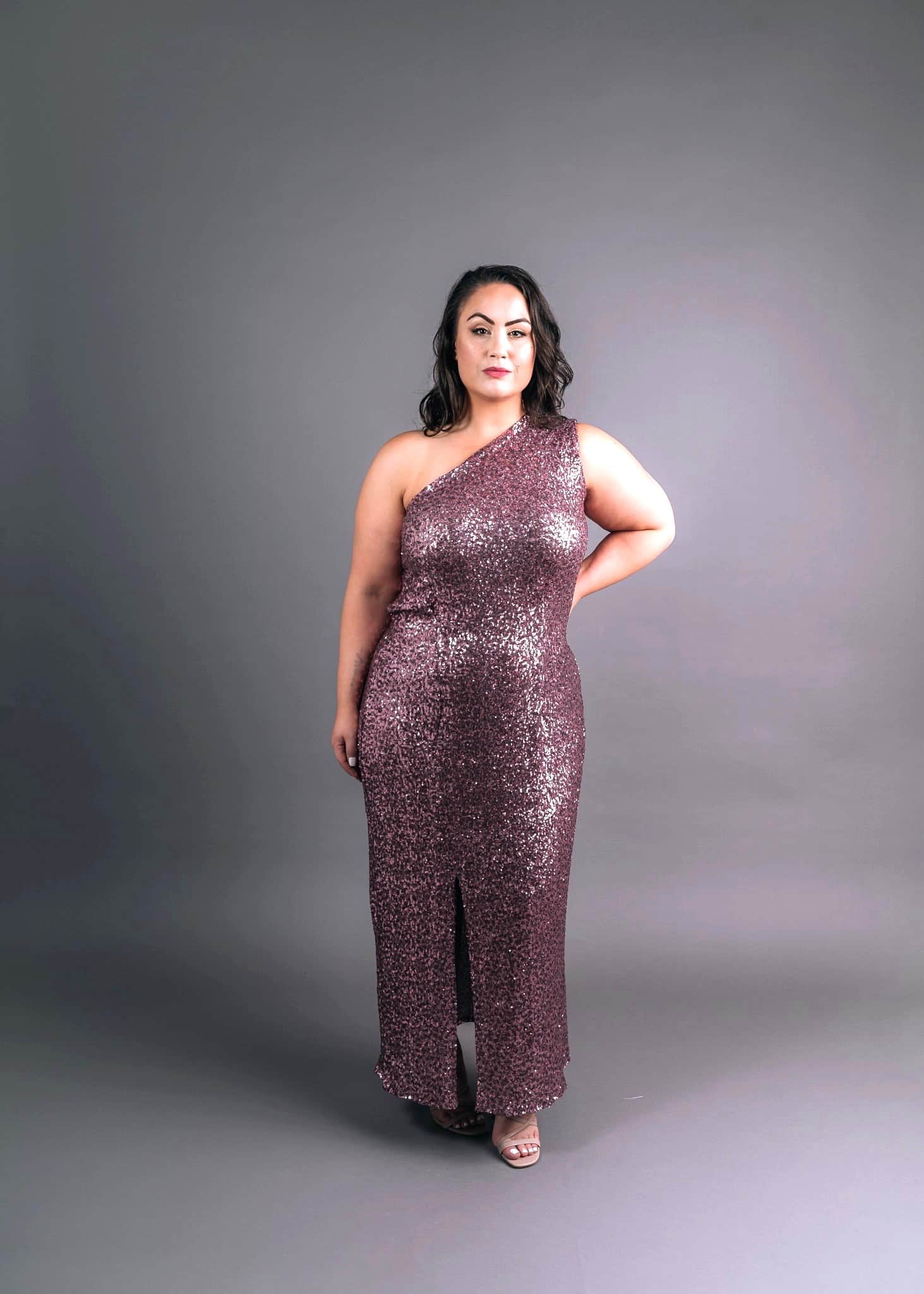 Model in mauve sequin evening gown with asymmetric one-shoulder design and front slit, front view