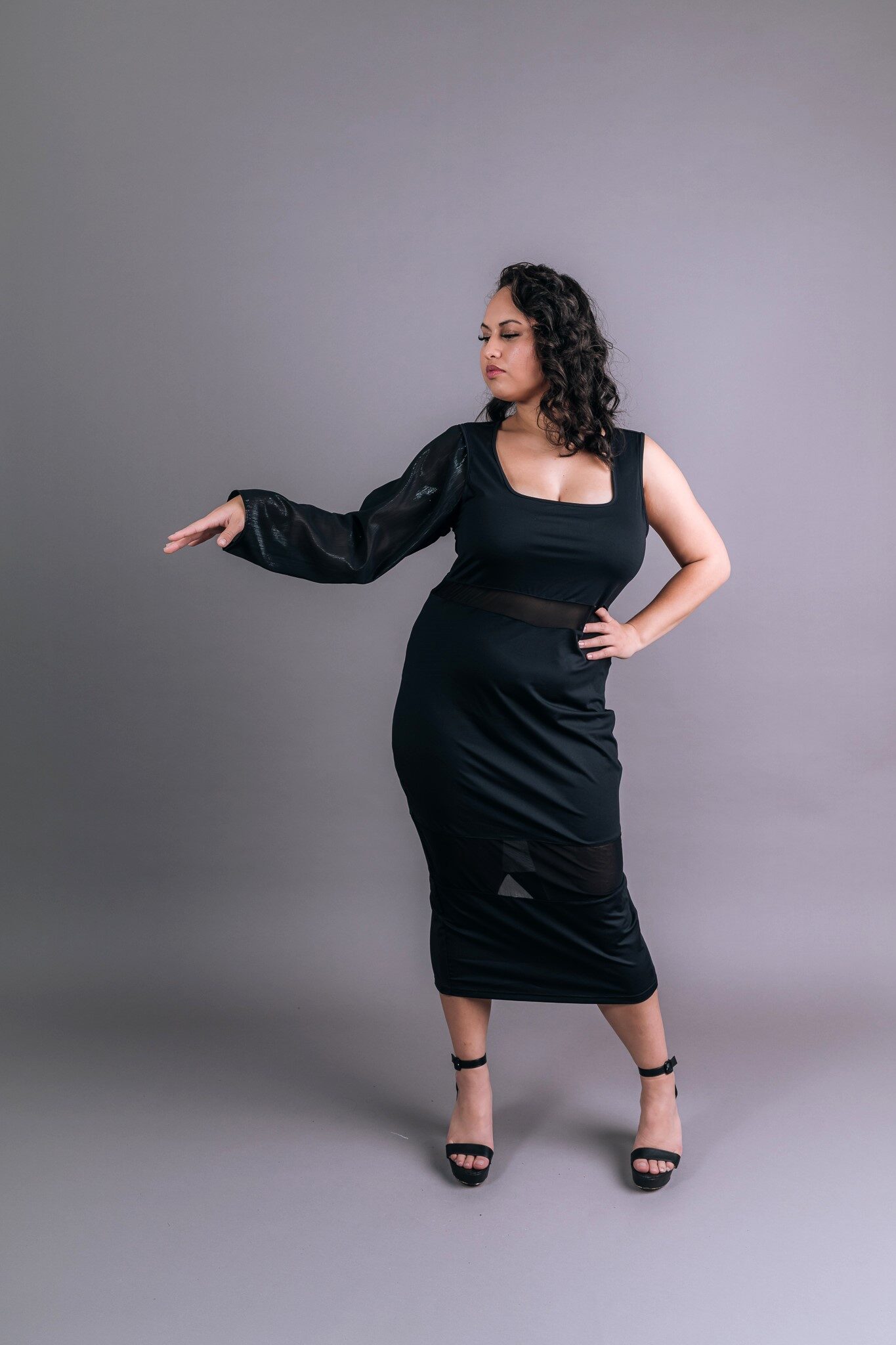 Attachable sleeve in sheer black organza worn on one arm of a black midi dress, front view – Art Kollocsion Auckland