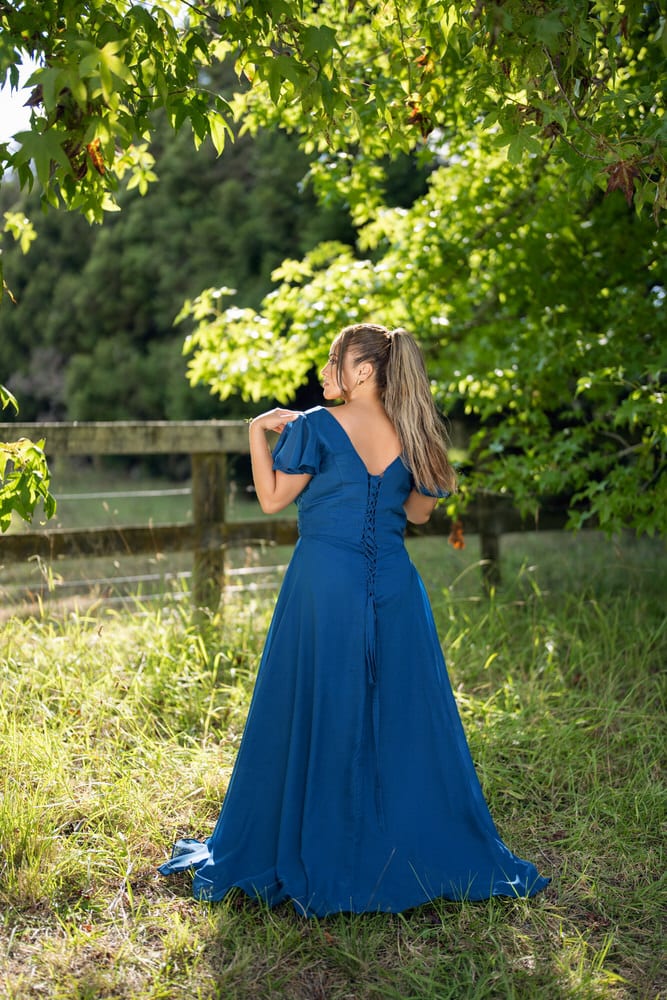 Back view of blue bridesmaids dress with flutter sleeves and button-up closure – Art Kollocsion Auckland