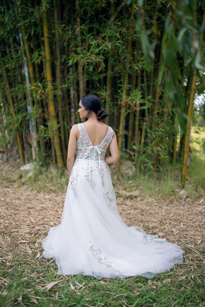 Side profile showing fitted bodice, gathered skirt, and dramatic chapel-length train