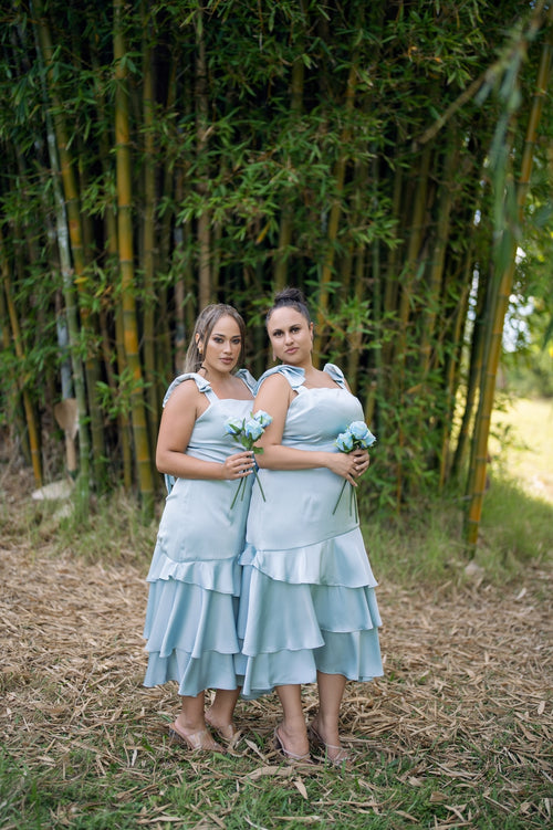 Pale blue satin midi dresses with bow-shoulder necklines and tiered ruffled hems – Art Kollocsion Auckland