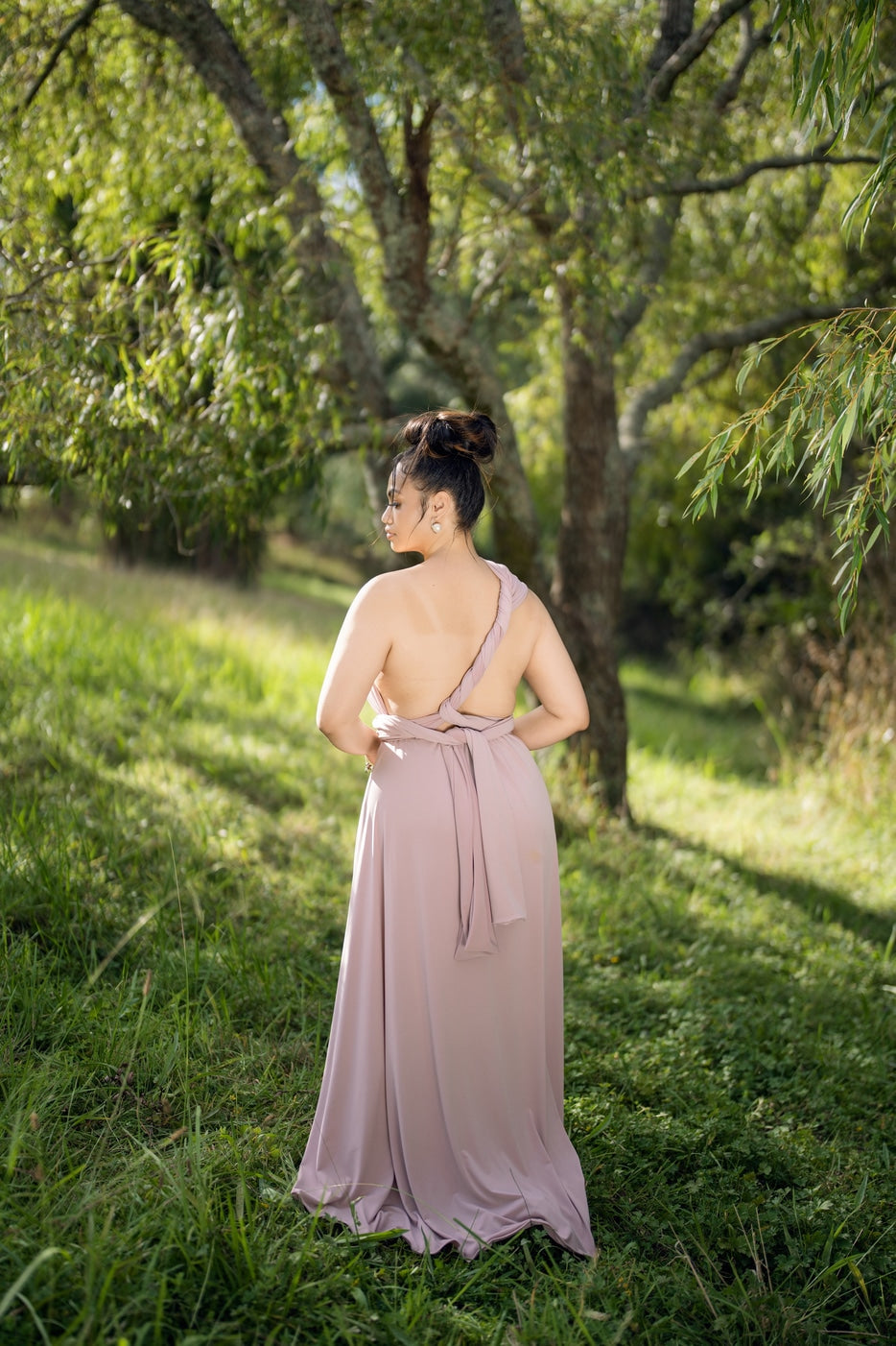 Back view of dusty pink infinity dress showing twisted cross strap and long waist tie sash