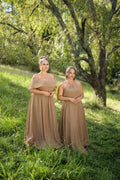 Two models wearing mismatched taupe bridesmaids dresses with contrasting necklines – Art Kollocsion Auckland