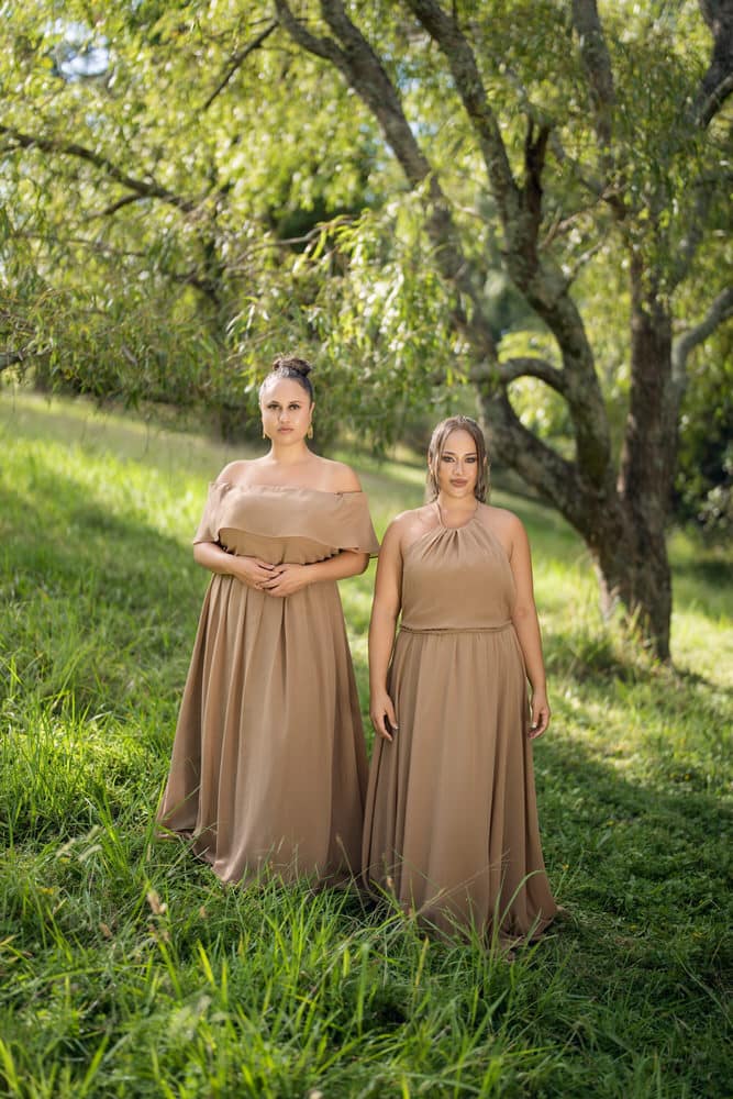 Left model in off-shoulder taupe gown, right model in halter-neck taupe dress, front view