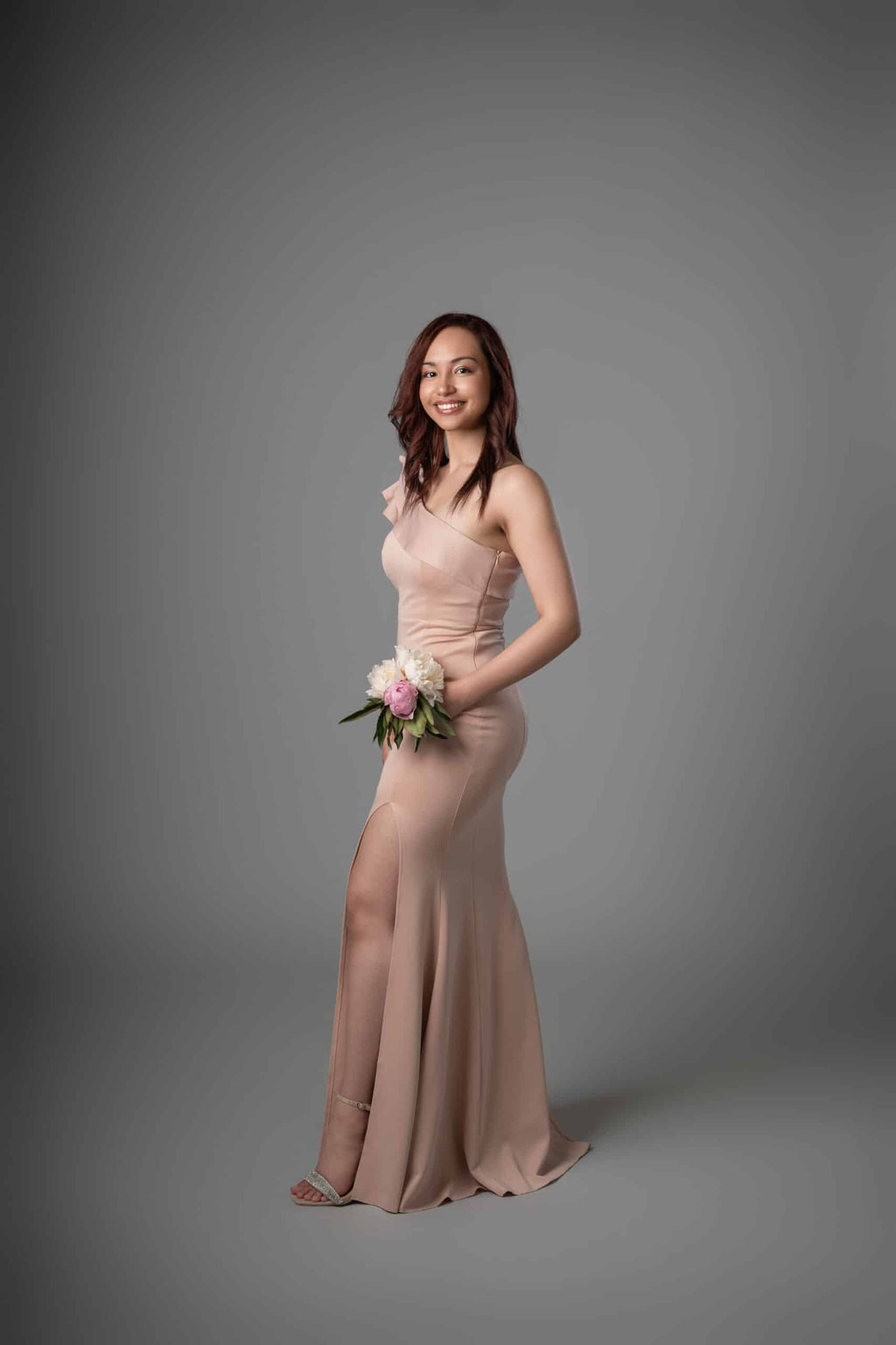 Side profile of blush mermaid dress showing form-fitting bodice and flowing skirt with slit
