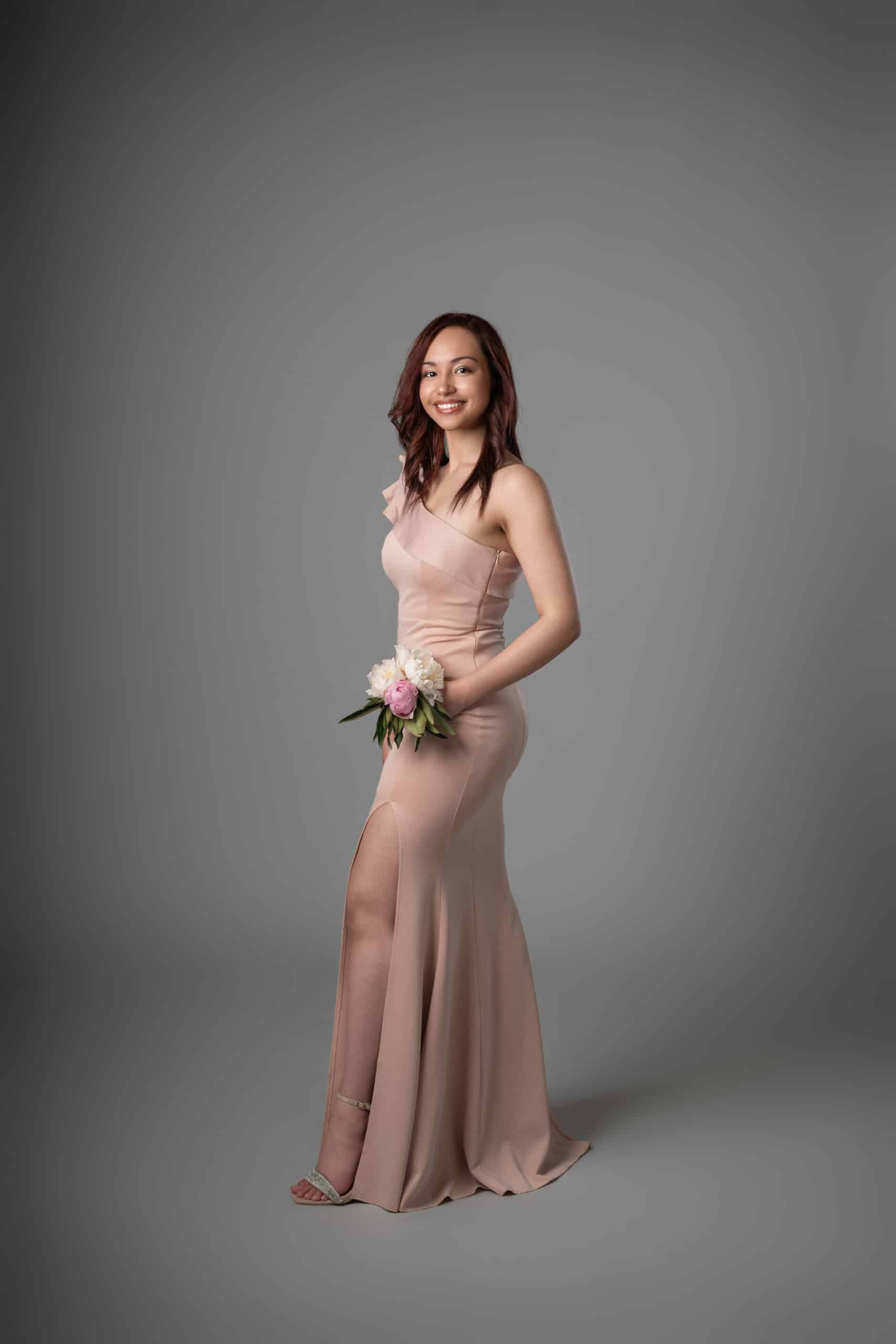 Side profile of blush mermaid dress showing form-fitting bodice and flowing skirt with slit