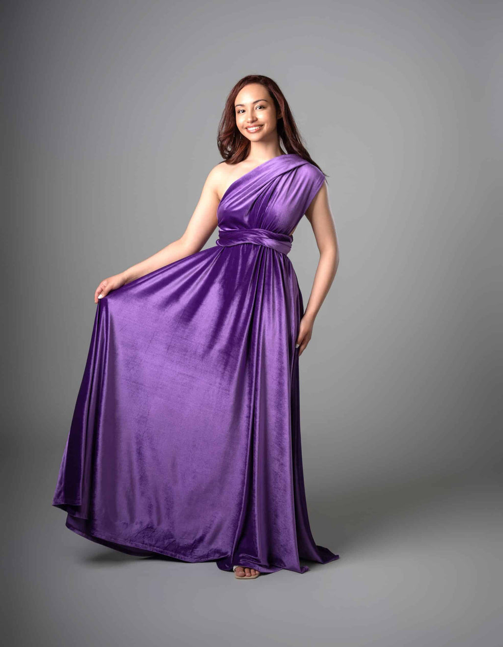 Model wearing Infinity Dress in purple, one-shoulder asymmetrical neckline with waist tie – Art Kollocsion Auckland