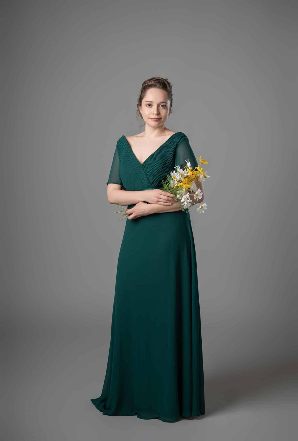 Emerald green chiffon bridesmaids dress with pleated V-neck and sheer flutter sleeves, front view – Art Kollocsion Auckland