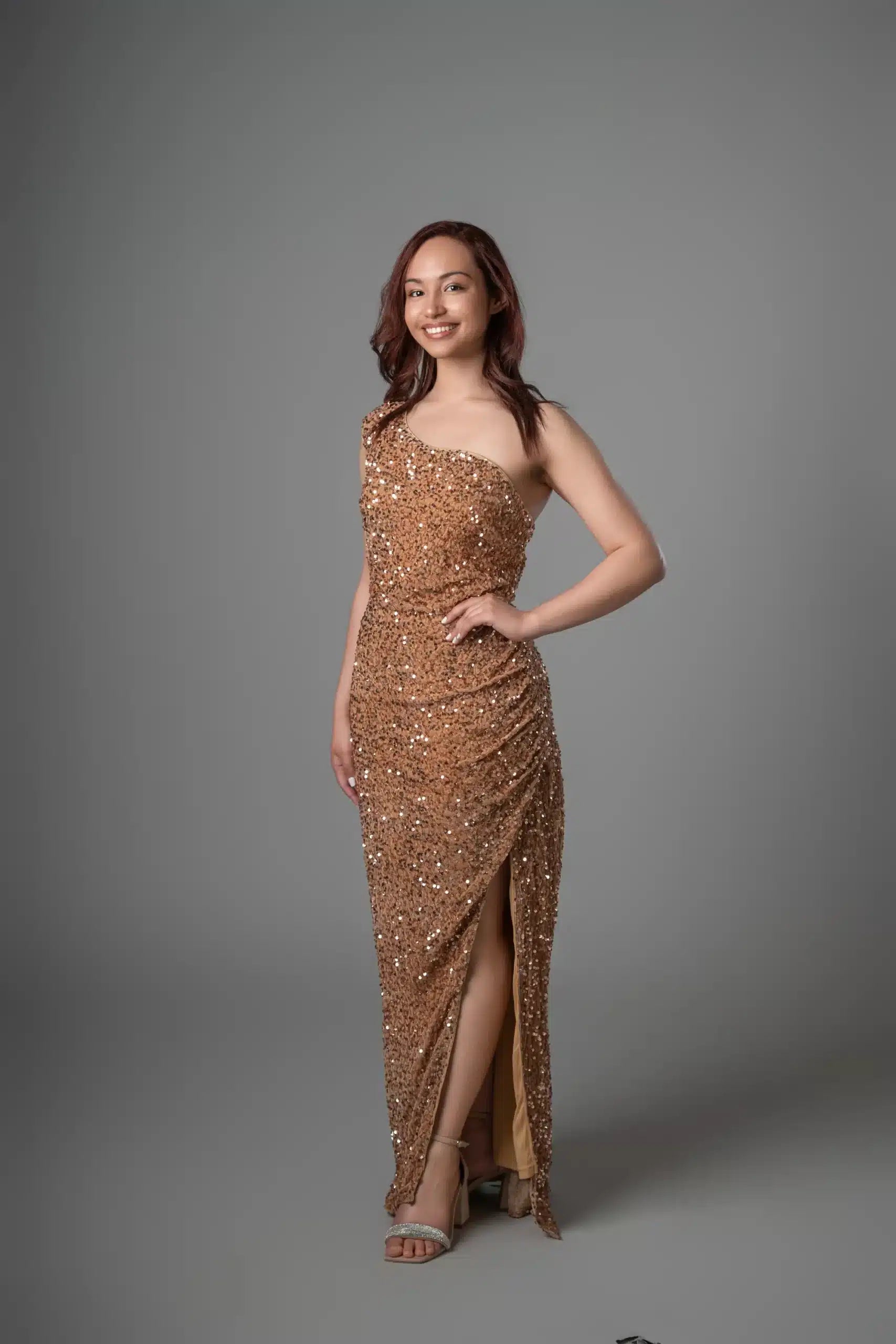 Gold sequin one-shoulder dress with ruched waist and asymmetric slit, model posture