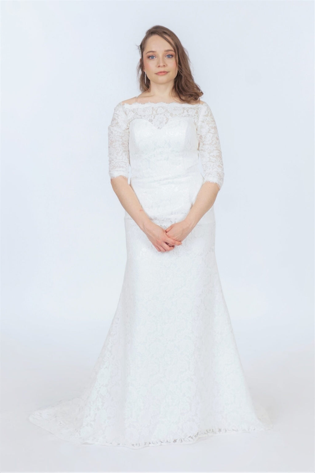 Off-shoulder guipure wedding dress with delicate lace bodice, narrow waist, and flowing mermaid skirt