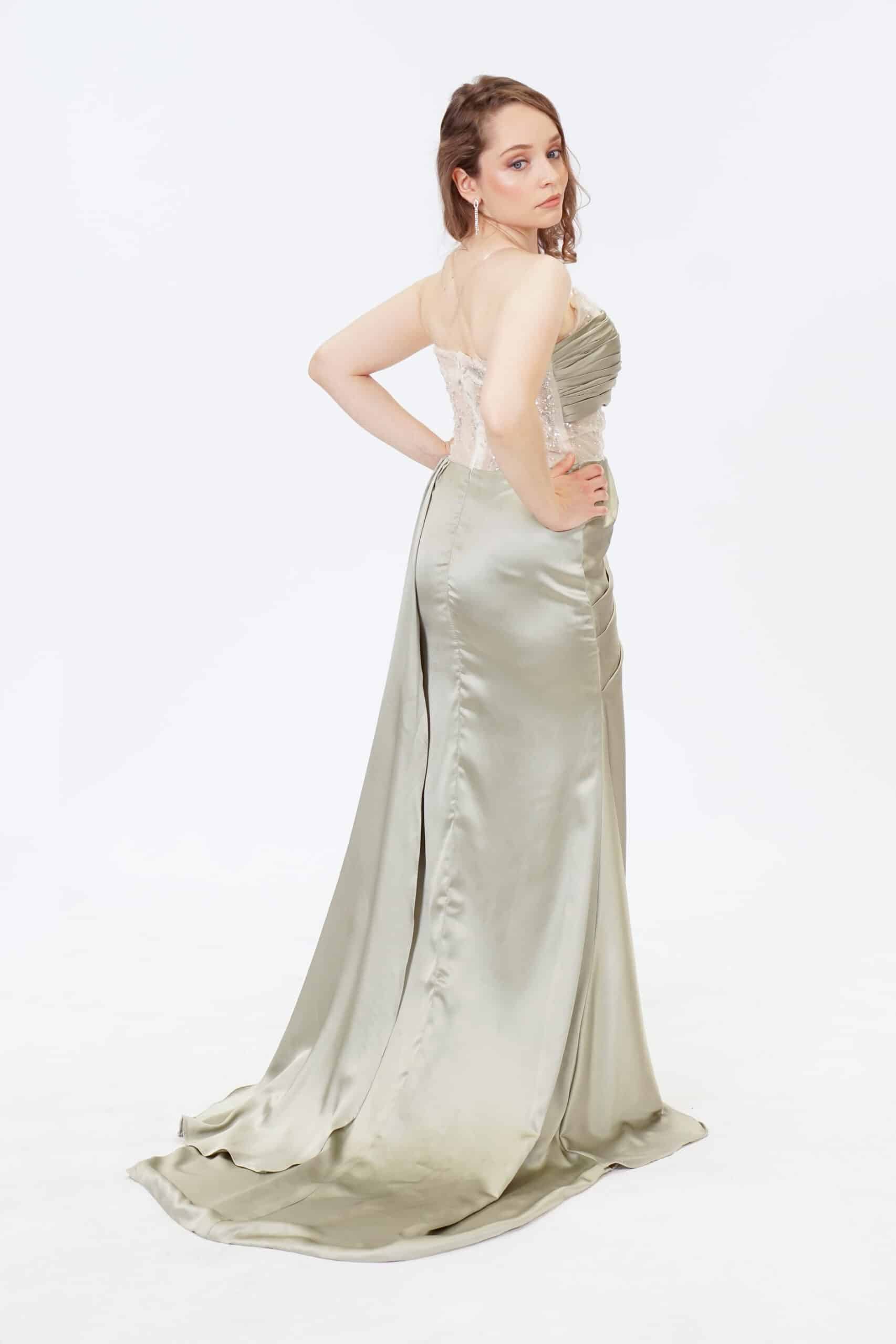 Back view of sage green evening gown showcasing open lace back and train