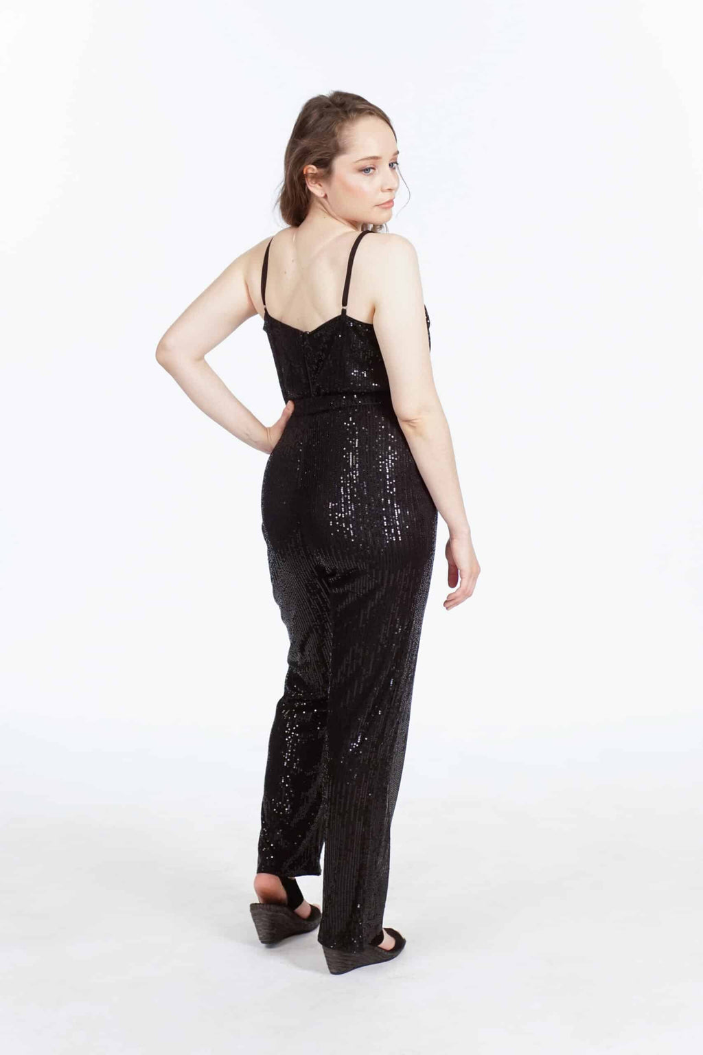 Back view of black sequined jumpsuit with low V-back, thin straps, and ribbed texture