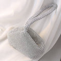 Close-up of rhinestone-studded handle and structured bag body showing intricate beading