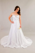 White satin wedding gown with deep V-neckline, spaghetti straps, and pleated skirt with train – Art Kollocsion