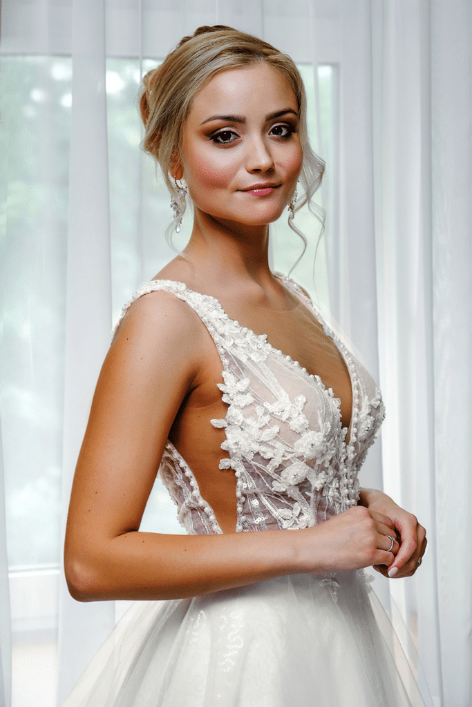 Model in custom ivory wedding dress with plunging V-neck and floral lace bodice – Art Kollocsion Auckland