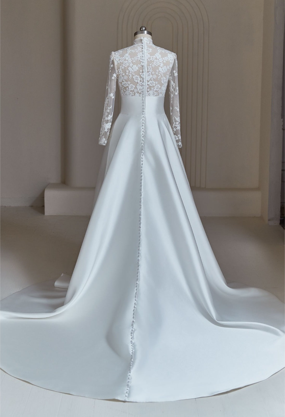 Back view of modest Mikado A-line bridal gown with lace illusion sleeves and buttoned court train
