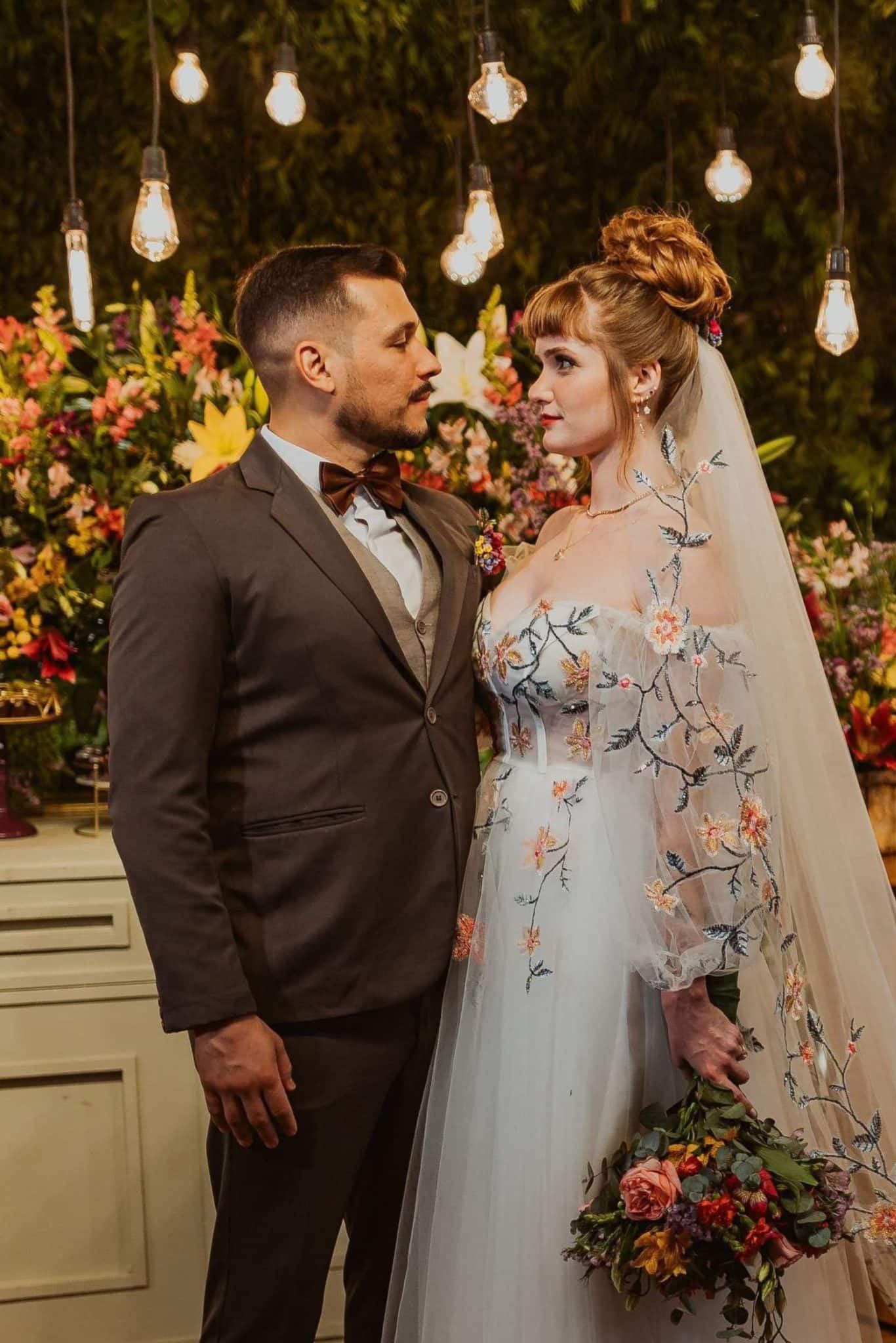 Close-up of embroidered floral bodice and off-shoulder sheer puff sleeves on custom bridal gown