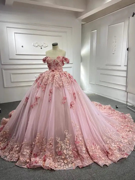 Front view of pink princess ball gown with cascading 3D flowers, tulle skirt and long train on mannequin
